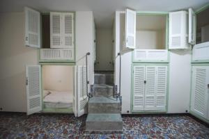 a room with white doors and a bed in it at Lebanon Hostel in Makhāḑat Nahr al Kalb