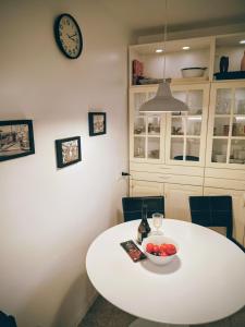 a white table with a bowl of fruit and a clock at 2 bedroom large modern apartment in Blanes Old Town 50m from the beach! in Blanes