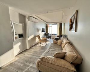 a living room with a large couch in a room at Deniz Hotel Kumburgaz in Büyükçekmece