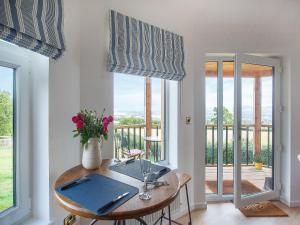 a dining room with a table and a balcony at The Nest - Uk50122 in Bodelwyddan