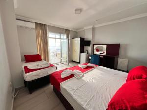 a bedroom with two beds with red and white sheets at Deniz Hotel Kumburgaz in Büyükçekmece