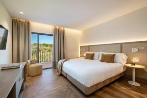 a hotel room with a bed and a balcony at Hotel Encinar de Sotogrande in Sotogrande