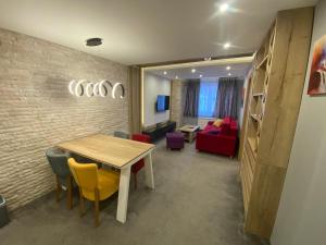 a dining room with a table and chairs and a couch at Hedonizam Jahorina 2 in Jahorina