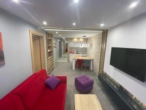 a living room with a red couch and a flat screen tv at Hedonizam Jahorina 2 in Jahorina +4 photos