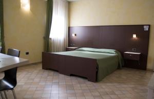 een slaapkamer met een bed, een tafel en een raam bij Affittacamere Il Pagliericcio in Ferrara