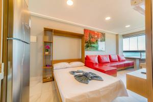 a bedroom with a bed and a red couch at Mirante de porto 108 in Porto De Galinhas +24 photos