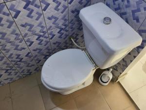 a bathroom with a white toilet and a sink at Chambre d'hôte in Lomé
