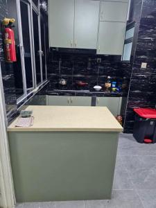 Una cocina con gabinetes blancos y encimera. en Venice Hill Condo Homestay, en Kampong Baharu Cheras Batu Sembilan