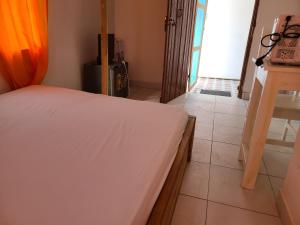 a bedroom with a white bed in a room at Chambre d'hôte in Lomé