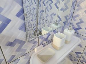 a bathroom with a toilet and two sinks and a mirror at Chambre d'hôte in Lomé