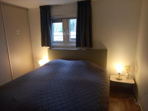 a bedroom with a blue bed and a window at Serene in Hoenderloo +38 photos