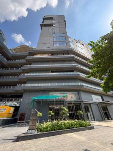 een hoog gebouw met bomen ervoor bij Vaelora Stay - Skyline Studio with glass wall in Ghaziabad +12 foto's