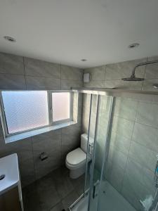 a bathroom with a toilet and a glass shower at Double room -Quite -Close to Elizabeth line in London