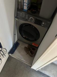 a washing machine with a pair of shoes in a room at Double room -Quite -Close to Elizabeth line in London
