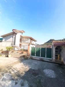 PERLA VERDE Rooms and parking في Case Nuove: أمامه بيت به سياج أخضر