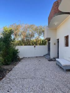 a white building with a bench in front of it at Abdalla's House in Al Aqālitah
