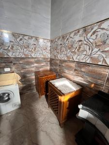 a bathroom with a toilet and a washing machine at Abdalla's House in Al Aqālitah +30 photos