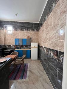 a kitchen with blue cabinets and a white refrigerator at Abdalla's House in Al Aqālitah
