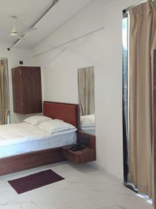 um quarto com duas camas e uma janela em Hare Krishna Beach Resort em Srīvardhan