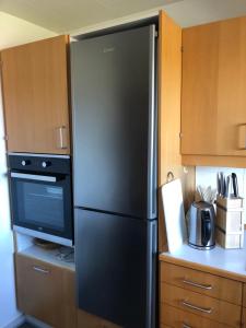 a kitchen with a black refrigerator and a microwave at Langø, ferielejlighed in Nakskov
