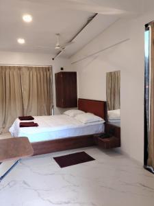 um quarto com uma cama grande e uma janela em Hare Krishna Beach Resort em Srīvardhan