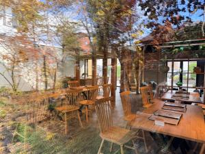 a restaurant with wooden tables and chairs and trees at Fukuchiya in Fujiyoshida