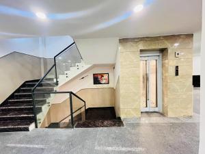 a staircase in a building with a glass railing at Hotel Aroma - Chattarpur in Gurgaon +22 photos