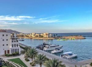 Una vista de un puerto deportivo con barcos en el agua. en Luxurious Golf and Sea View 2 Bedroom Apartment, en As Sīfah
