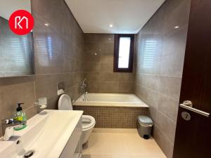 Un baño con bañera, inodoro y lavabo. en Luxurious Golf and Sea View 2 Bedroom Apartment, en As Sīfah