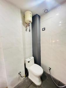 a bathroom with a toilet and a water tank at Hotel Aroma - Chattarpur in Gurgaon