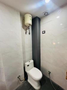 a bathroom with a white toilet and a water tank at Hotel Aroma - Chattarpur in Gurgaon