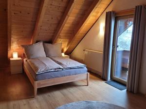 een slaapkamer met een bed op een zolder met een raam bij Ferienparadies Vogelsbergliebe in Grebenhain