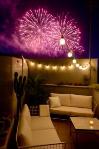 a room with a couch and fireworks in the background at HOMESTAY rooftop in Catania