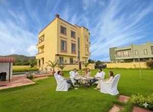 a group of people sitting around a table on a lawn at The Ranthambore Samrajya Tiger Seven in Sawāi Mādhopur