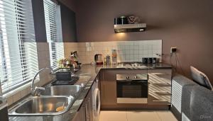 uma cozinha com pia e fogão em Oceans Deep at Lagoon Terrace - Knysna! em Knysna