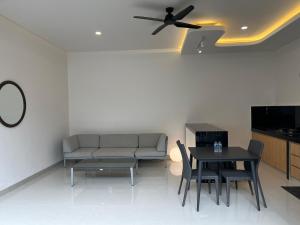 een woonkamer met een bank en een tafel met een plafondventilator bij Honeymoon Villa canggu in Sempidi