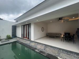 een huis met een zwembad en een woonkamer bij Honeymoon Villa canggu in Sempidi