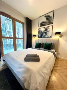 a bedroom with a large white bed with green pillows at Rudnickiego, Fort Bema, free parking by Cosmo Spirit in Warsaw