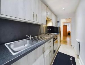 una cocina con fregadero y estufa en Apartment near Glasgow Airport, en Paisley