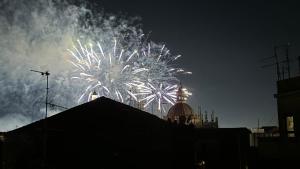 a fireworks display in the sky over a building at HOMESTAY rooftop in Catania