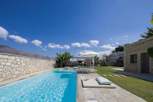 a swimming pool in a backyard with a stone wall at Thalmargia Villas, with Pool, Hot Tub & Ultimate Peace, By ThinkVilla in Garazo