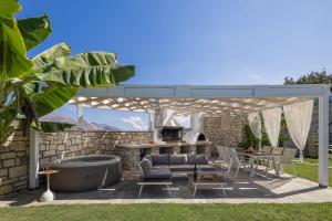 a patio with a grill and a table and chairs at Thalmargia Villas, with Pool, Hot Tub & Ultimate Peace, By ThinkVilla in Garazo