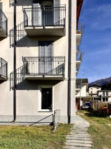 a white building with balconies and a walkway at casaLaRadice in Tirano