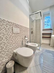 a bathroom with a toilet and a tub and a shower at casaLaRadice in Tirano +13 photos