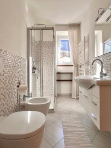 a white bathroom with a tub and a sink at casaLaRadice in Tirano