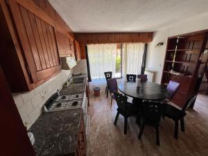 een keuken met een tafel en een keuken met een fornuis bij Chalet del Sur in Villa Gesell