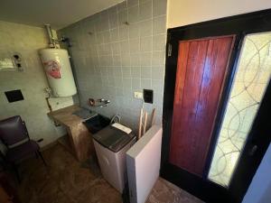 een badkamer met een toilet en een houten deur bij Chalet del Sur in Villa Gesell +9 foto's
