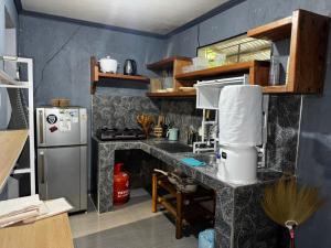 eine Küche mit einer Theke mit einem Kühlschrank und einem Herd in der Unterkunft Uchi in Sampong + 9 Fotos