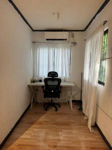 ein Büro mit einem Schreibtisch und einem Stuhl vor einem Fenster in der Unterkunft Uchi in Sampong