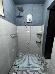 ein Bad mit einer Dusche und Fliesenboden in der Unterkunft Uchi in Sampong